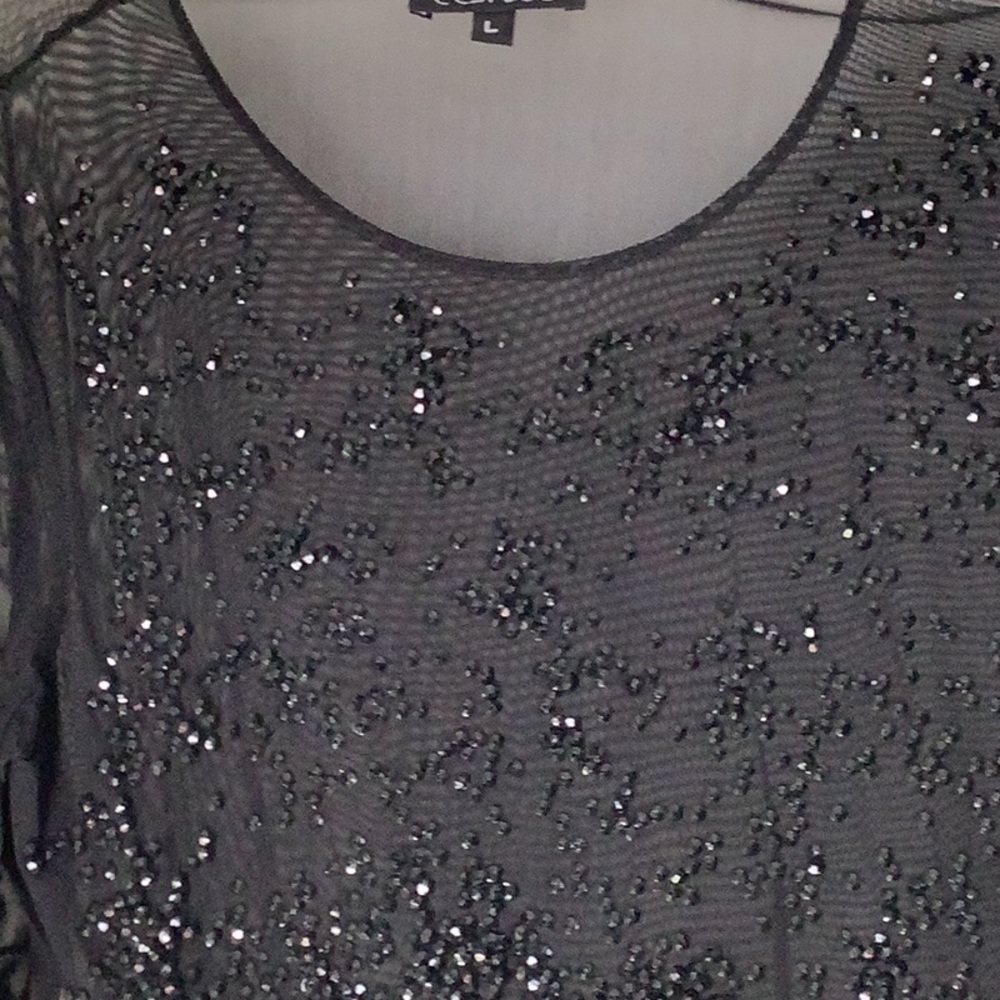 Women’s sheer top with black top with black beads.
